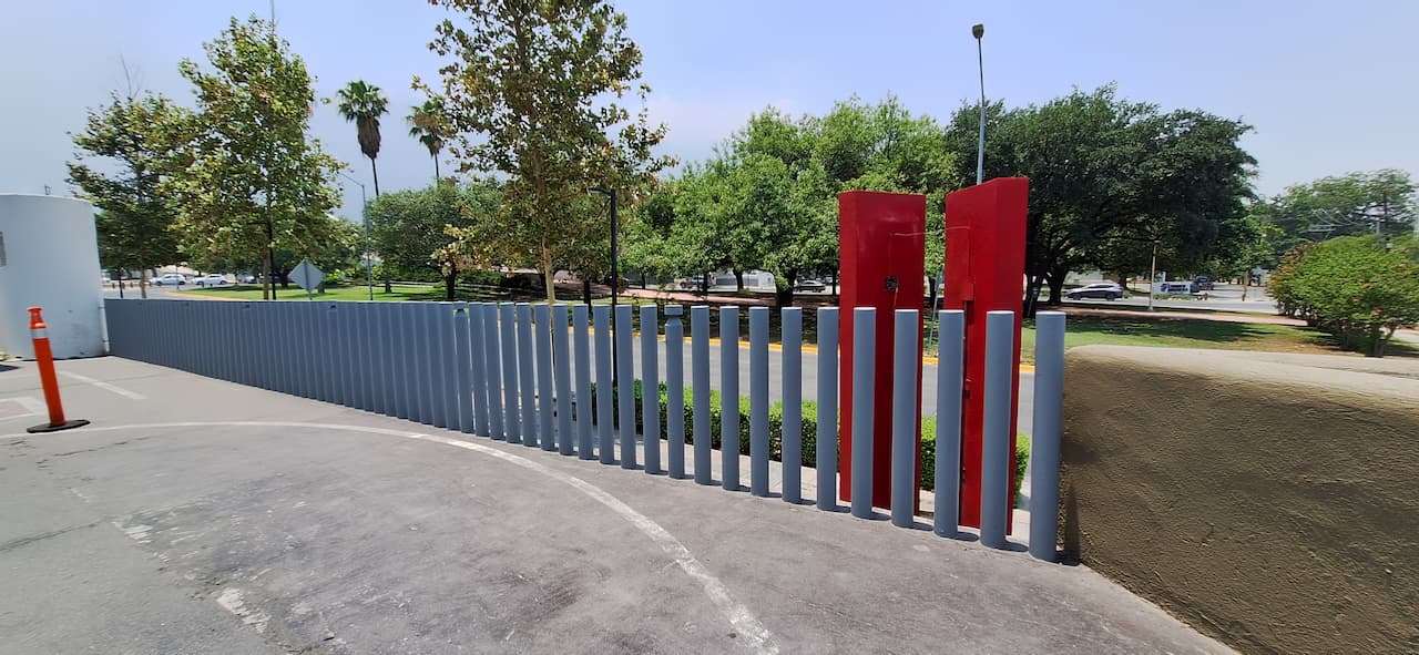 Valla moderna construida con columnas de acero sin costura de MMTubería en un entorno urbano con árboles de fondo