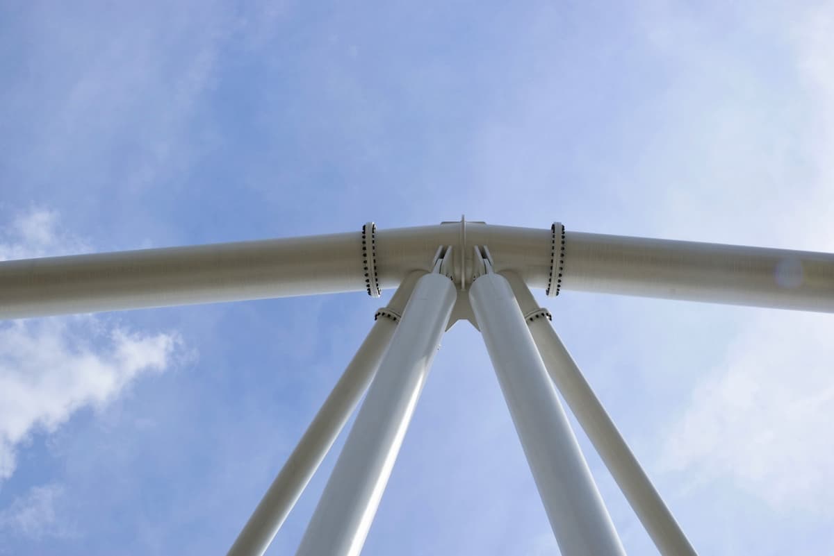 Vista desde abajo de una estructura de soporte hecha con tuberías sin costura de acero de MMTubería, con el cielo de fondo